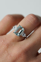 Anillo de compromiso aguamarina corte esmeralda tres piedras