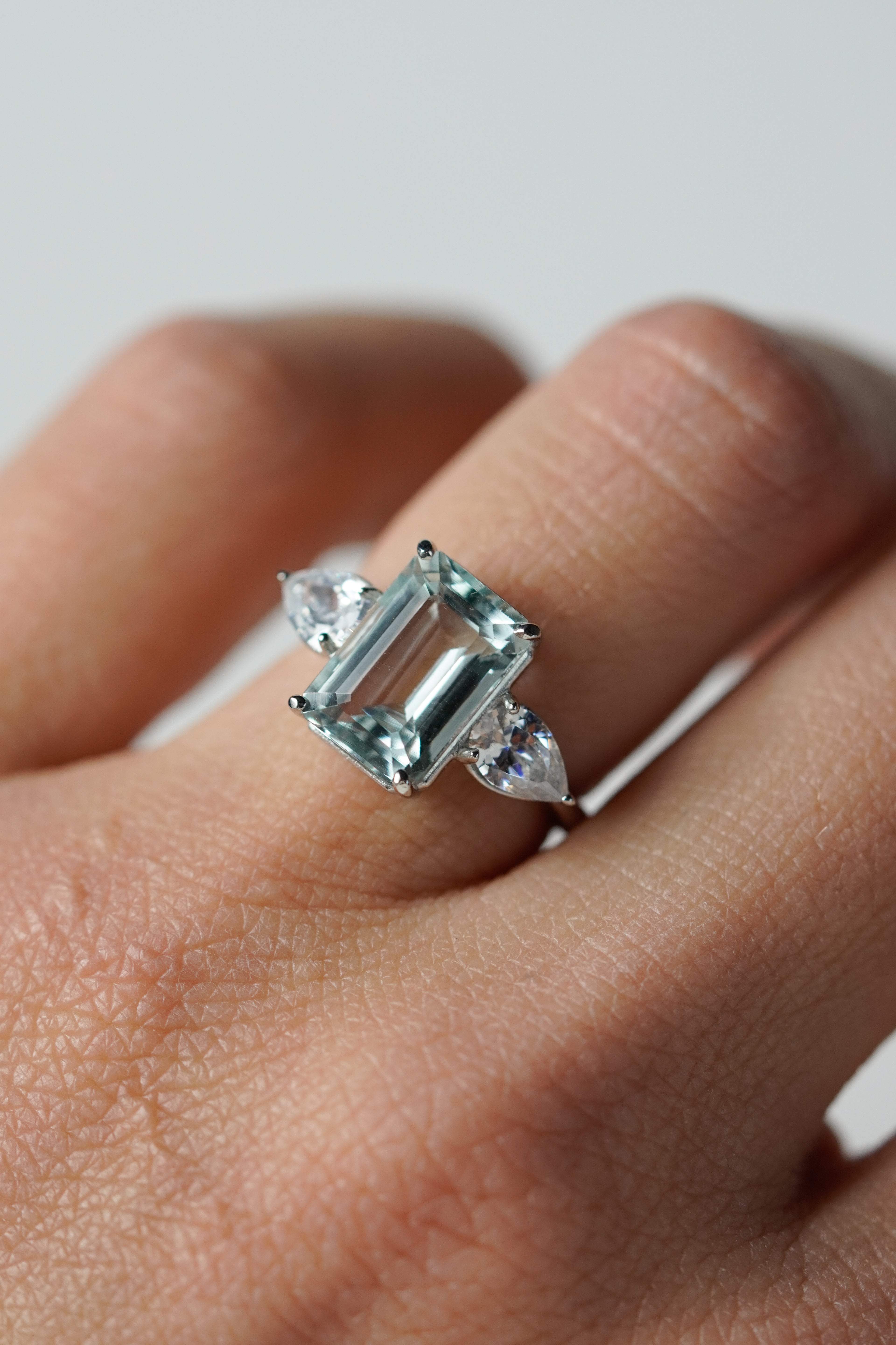 Anillo de compromiso aguamarina corte esmeralda tres piedras